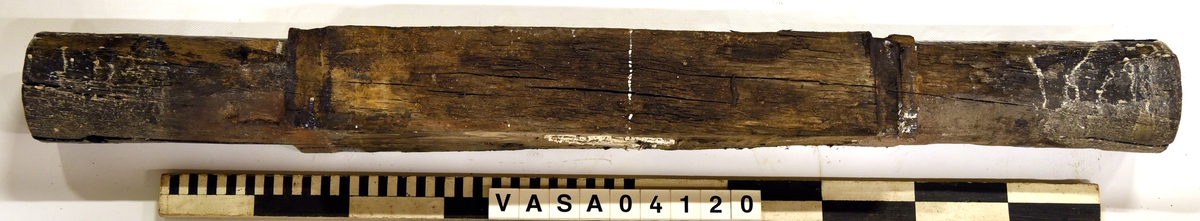 Lavettaxel fram. Välbevarad med två hål för tränagel. 

Axle front edge of a gun carriage, good condition, two large pin holes.