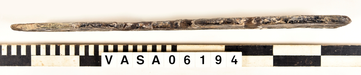 Rektangulär bräda med en kvist, en halft i halv på ena lång sidan och på andra lång sidan och en fjäder. Original tjocklek finns runt kvisten.
Extremt vittrad på alla ytor och hörn. Salthalt 1

Tillhörig information:
Not längs ena långsidan. Spår av tappning längs ena kortsidan. Urtag på andra långsidan.