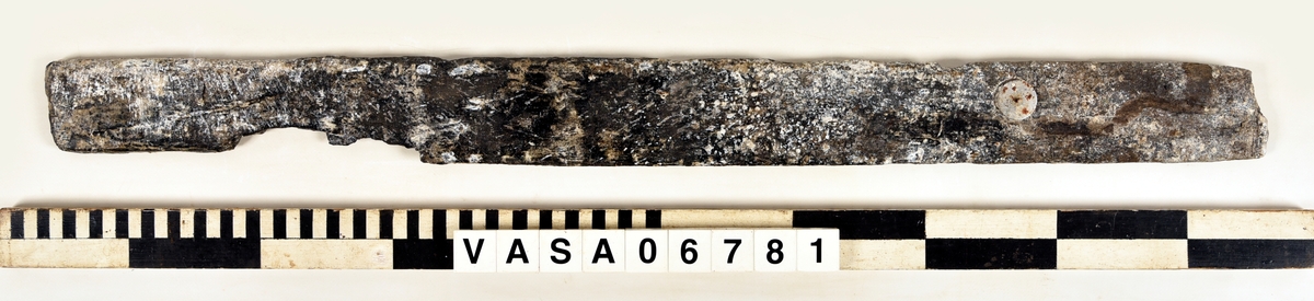 Bräda med en avbruten ände och ett urtag, men bara en del av urtagets sidar finns kvar.
Mycket vittrad på alla ytor och hörn. Salthalt 0

Tillhörig information:
Bräda (ramstycke). Urtag för tappning.