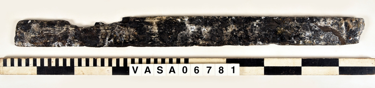 Bräda med en avbruten ände och ett urtag, men bara en del av urtagets sidar finns kvar.
Mycket vittrad på alla ytor och hörn. Salthalt 0

Tillhörig information:
Bräda (ramstycke). Urtag för tappning.