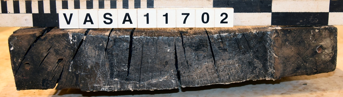 Lavettbotten, flertal sprickor med splitter, stor trä knut i mitten.

För mer information se Dokumentationsblankett under Referenser – Länkade filer.

Text in english:
Heavely cracked split gun-bed, large central knot.

For more information see the Documentation form under References – Linked files.