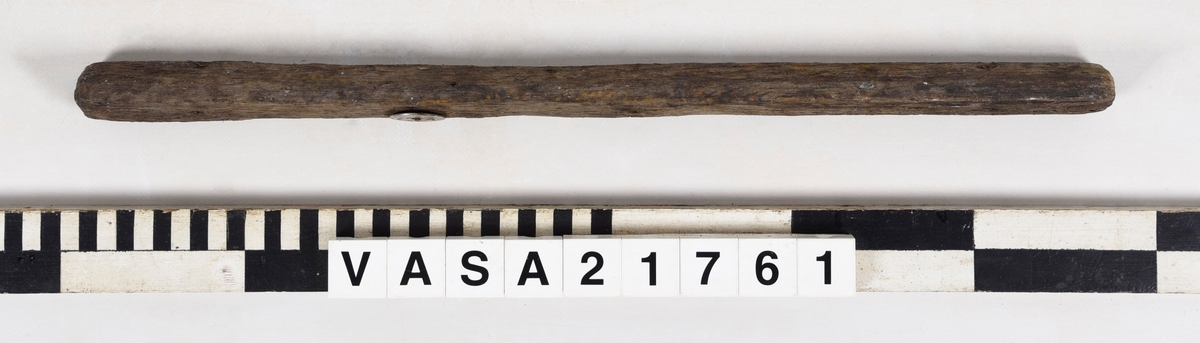 List med en vinklad yta och tre spikhål.
Mycket vittrad i ändarna. Flagnar, mycket torr.