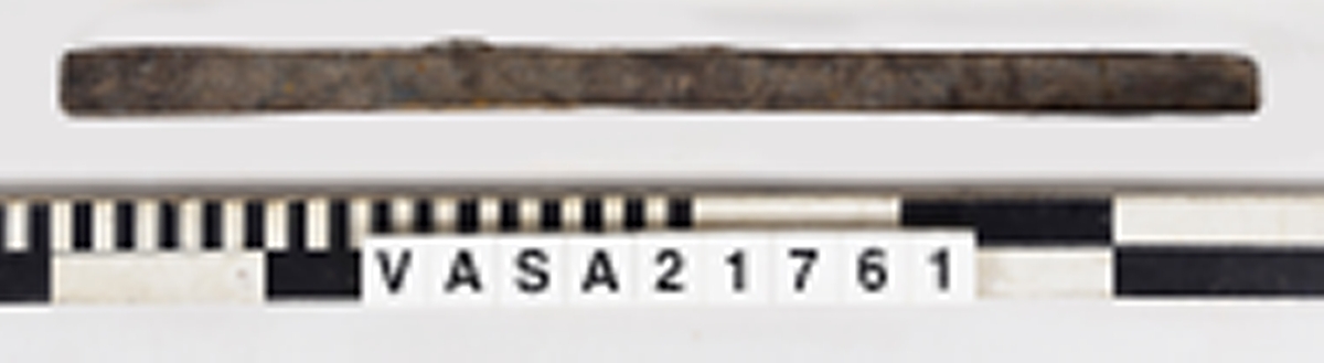 List med en vinklad yta och tre spikhål.
Mycket vittrad i ändarna. Flagnar, mycket torr.