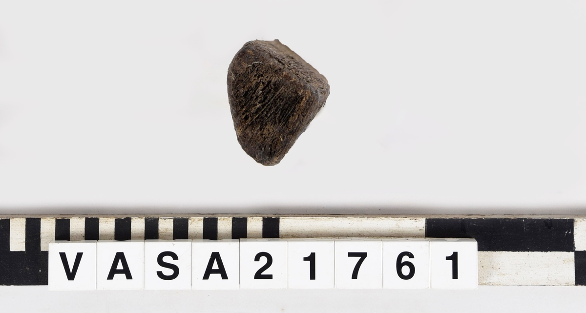 List med en vinklad yta och tre spikhål.
Mycket vittrad i ändarna. Flagnar, mycket torr.