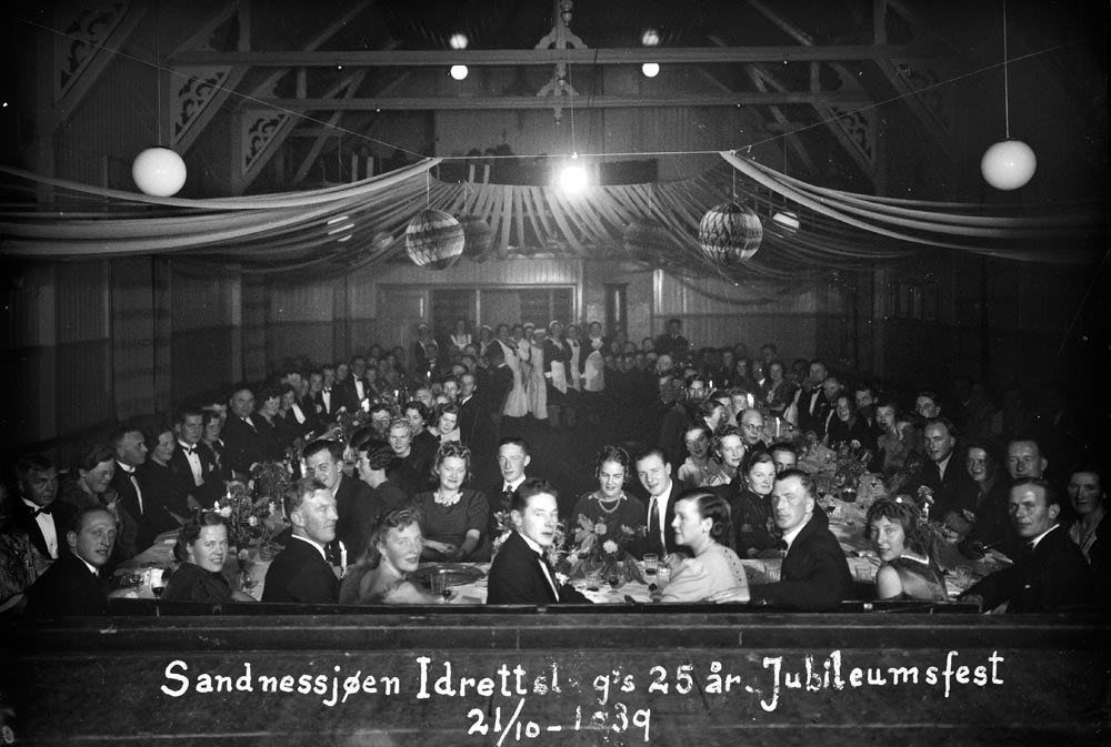 Alstahaug, Sandnessjøen. Festpyntet lokale. Gjester rundt bordet ved Sandnessjøen idrettslags 25 års jubilemsfest, 21.10.1939.