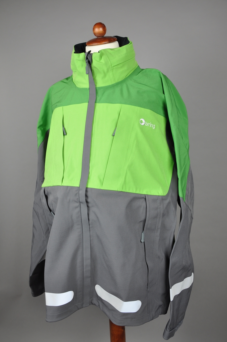 Grønn, mørkegrønn og grå skalljakke. Brings logo på ryggen og et mindre brodert logomerke på fremsiden. Jakken er størrelse "Large" i herremodell. Innsiden er foret med tynt polyester fleece. 

Reflekser på fram- og bakside og på ermer. Jakken har to brystlommer, den ene har en foret mobillomme på innsiden. To store side lommer, og åpning med glidelås under ermene. I kragen er det festet en hette, den ligger i en innsydd lomme i kragen og kan tas ut ved behov.