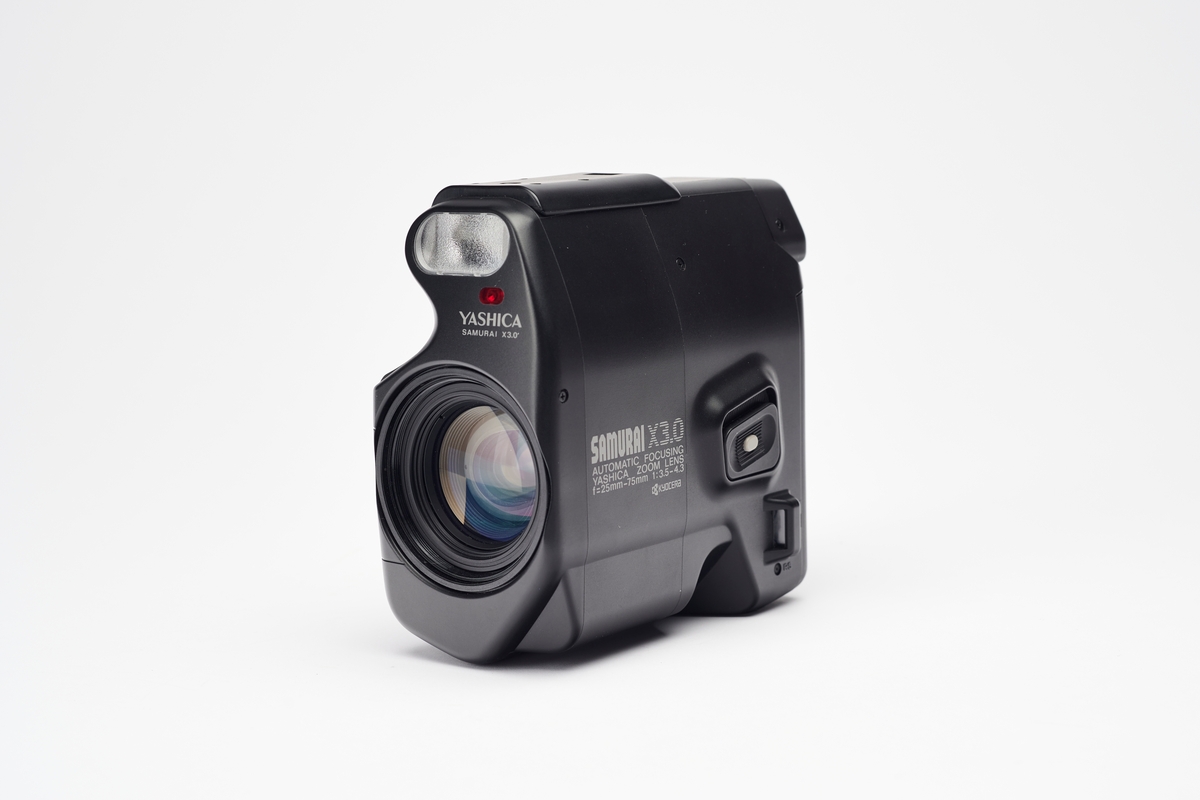 Det futuristiske Samurai X3.0 fra 1987 ligner på de kompakte videokameraene som var poulære på denne tiden, men er et autofokus speilreflekskamera for 35mm film. Det er et SLR kamera, men kalles også ZLR (zoom lens reflex).  Kameraet tar bilder i halvformat og eksponerer 72 bilder på en film. Filmtransporten er motorisert og dato/tid kan printes på filmen.
Kameraet er av de første "bridge"-kameraene som er enkle å betjene, men med større billedkvalitet enn et kompaktkamera. Kameraet har et ikke-utskiftbart AF-zoom objektiv, elektronisk lukker 2-1/500 sek. og en innebygget blits som aktiveres automatisk.