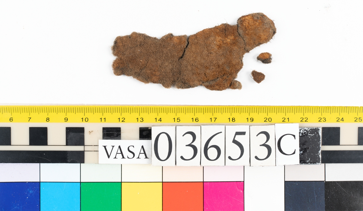 Textilfragment. Fem fragment uppdelade på 03653a-c. Fnr 03653a omfattar tre fragment i ull vävda i tuskaft som ser ut att ha varit valkade. De har idag en brun färg.
Fnr 03653b är ett fint/tunt fragment som är grått med rostfläckar. Fragmentet är av ull vävt i tuskaft och ser ut att ha varit valkat.
Fnr 03653c är filt och har idag en brun färg.


Textildokumentation 2018:


Ingår i kontextgrupp: ÖB31

Fyndnumret 03653a  innehåller 3 fragment av två typer (ÖB31.1:1-2, ÖB31.2:1).
Tygerna är tätt vävda med ruggade ytor. Invasiva fibrer, löst liggande, av ljus kulör finns på alla tre fragmenten. Tygerna är snarlika men skiljer sig bl.a åt vad det gäller trådtäthet.

ÖB31.1:1-2 har slitna kanter samt bortnött lugg på vissa ställen. 
ÖB31.1:1 Ett rostigt avtryck i form av en dubbelbåge, möjligtvis av en hyska  eller en hake. Inga stygnhål syns. Tillskurna kanter på tre sidor. Antydan till tillskuren svängd kant med bristningar utefter en söm. 
ÖB31.1:2 Ett hörn med förhårdnad av rost. Ena sidan har bevarad lugg men andra sidan bortsliten lugg. Ett svagt avtryck i form av en dubbelbåge, möjligtvis av en hyska  eller en hake tillsammans med stygnhål. Antydan till tillskurna kanter på två sidor.
ÖB31.2:1 Bevarade tillskurna kanter varav två med stygnhål och spår av kaststygn. En del stygnhål har rester av rost. På ena sidan finns ett avtryck i form av ett C.  


TEKNIK Typ.nr: ÖB31.1:1-2
Teknik
Trådsystem 1
Trådtäthet (tr/cm): 9-11
Garn nr: 1
Fibermaterial: ull
Garngrovlek (mm): 0,9-1,1
Antal trådar: 1
Spinnriktning: s
Spinnvinkel (grader): 18,3-30,7
Färg:  brun, originalfärg okänd

Trådsystem 2
Trådtäthet (tr/cm): 9-11
Garn nr: 2
Fibermaterial: ull
Garngrovlek (mm): 0,7-0,9
Antal trådar: 1
Spinnriktning: z
Spinnvinkel (grader): 24,8-35,4
Färg: brun, originalfärg okänd

TEKNIK Typ.nr: ÖB31.2:1
Trådsystem 1
Trådtäthet (tr/cm): 10-11
Garn nr: 1
Fibermaterial: 
Garngrovlek (mm): 0,7-0,9
Antal trådar: 1
Spinnriktning: z
Spinnvinkel (grader): -
Färg:  brun, originalfärg okänd

Trådsystem 2
Trådtäthet (tr/cm): 10-11
Garn nr: 2
Fibermaterial: ull
Garngrovlek (mm): 0,7-1,0
Antal trådar: 1
Spinnriktning: s
Spinnvinkel (grader): -
Färg: brun, originalfärg okänd

Fyndnumret 03653b  innehåller 1 fragment (ÖB31.3:1).
Ett mycket tätt vävt tyg med lugg i en ljusare kulör. Ytbehandlad på båda sidorna. På ena sidan är luggen slät och blank samt lutar i en riktning.
Bevarade tillskurna kanter på fyra av fem sidor. Fält med avtryck av rost. Ljusare på ena sidan.


TEKNIK Typ.nr: ÖB31.3:1
Trådsystem 1
Trådtäthet (tr/cm): 27-29
Garn nr: 1
Fibermaterial: ull
Garngrovlek (mm): 0,18-0,22
Antal trådar: 1
Spinnriktning: s
Spinnvinkel (grader): 29-35
Färg: originalfärg okänd 

Trådsystem 2
Trådtäthet (tr/cm): 23-26
Garn nr: 2
Fibermaterial: ull
Garngrovlek (mm): 0,18-0,26
Antal trådar: 1
Spinnriktning: z
Spinnvinkel (grader): 30
Färg: originalfärg okänd


Fyndnumret 03653c  innehåller 1 större samt två mindre fragment. (ÖB31.4:1).
En textil av filtad ull.  Avtryck av järn.

TEKNIK Typ.nr: ÖB31.4:1
Fibermaterial: ull, tunna brunna med inslag av mörkare tjockare fibrer.
Färg: olika nyanser av brunt


Dokumenterad av JH nov 2017, AS maj 2018.
Införd av MS juni 2018.
