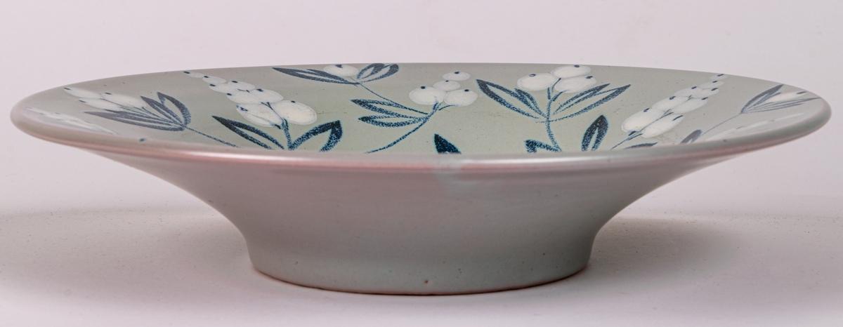 Handmålad skål i modell 4308 med dekor BV; med blå och vita bärkvistar på duvblå botten, blå rand i botten. Formgiven av konstnär Eva Jancke-Björk 1934.