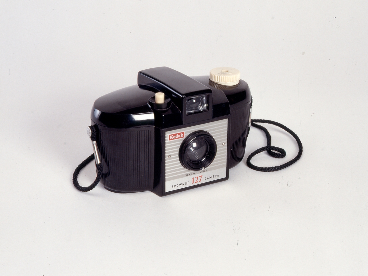 Brownie 127 er en serie kameraer produsert av Kodak Ltd. (England) fra 1952 til 1967. Den første av de tre modellene i serien, ble raskt et veldig populært snapshot-kamera. De første to årene ble det solgt over en million, og suksessen fortsatte. 
Dette kameraet, modell to, ble produsert fra 1959 og frem til 1963. Kameraet er utstyrt med et Dakon f/11 objektiv. Negativene har et format på 6 x 4 cm på 127 film.
Kodak innførte benevnelsen "Dakon" for objektiv lagd av akryl plastikk tidlig på 1950 tallet. "Acrylic plastic" ble utviklet gjennom 1930 tallet,  kjent som "Acrylic glass", men også "Plexiglass". Produktet ble stadig videreutviklet til flere bruksområder, og med andre benevelser.
Kodak introduserte denne nyvinningen i sin kameraoptikk, og den ble først tatt i bruk for Kodak Brownie Star-serien; Starlet og Starflash.
Blant fordelene med bruk av plastprodukter, var lavere produksjonskostnader, og dermed rimeligere produkter for forbrukeren. Dakon objektiver kunne ha en kortere levetid enn tradisjonelle objektiver av glass, og varierende kvalitet for det fotografiske resultatet.
"Dakon" blir av Kodak, først tatt i bruk som benevnelse på en enkel lukker, brukt i ulike foldekameraer gjennom 1930- og 40-tallet.