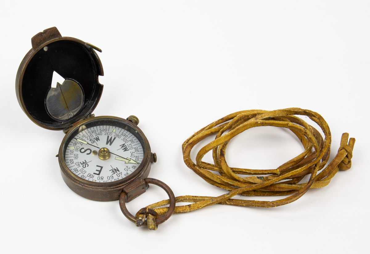 Fickkompass, US Engineer Corps. Tillverkad i Schweiz. Kompasshus och lock i brons. Fluorecerande nordpil och kurspil. Fästögla med läderrem.