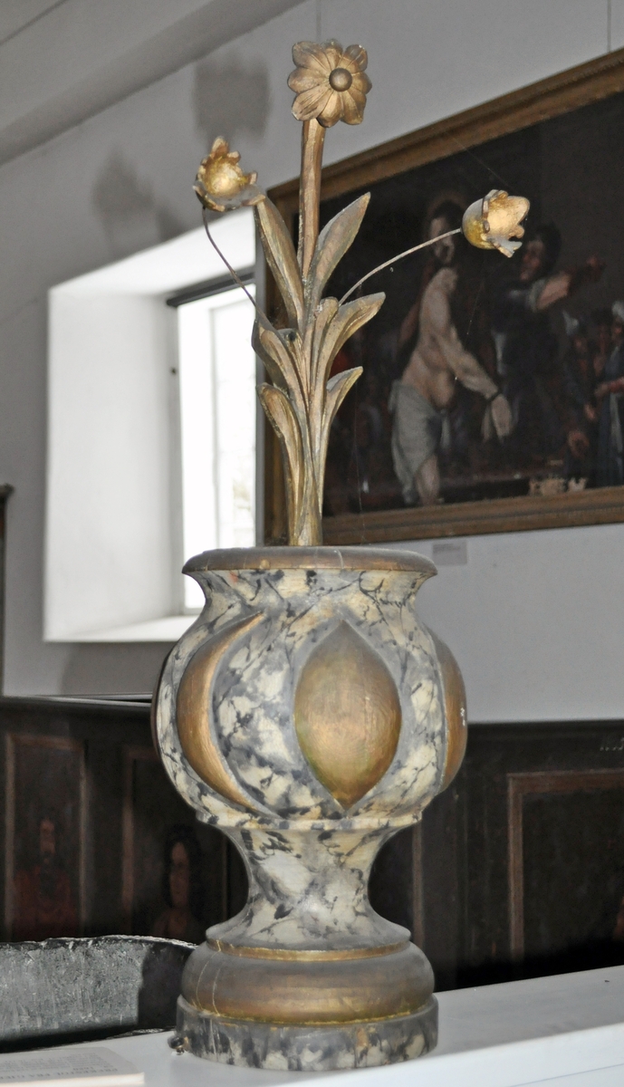 Fra protokollen (Hoel):
Trevase med fritstaaende blomsterprydelser, enten fra prækestolhimlen eller fra korrekkverket i Solum kirke.
