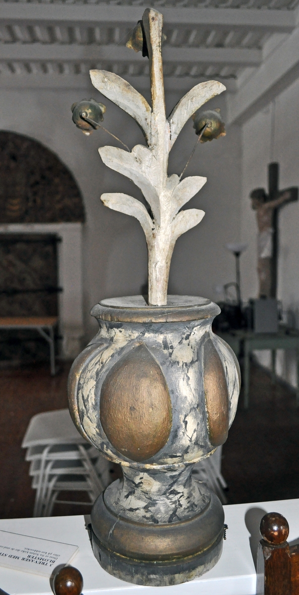 Fra protokollen (Hoel):
Trevase med fritstaaende blomsterprydelser, enten fra prækestolhimlen eller fra korrekkverket i Solum kirke.