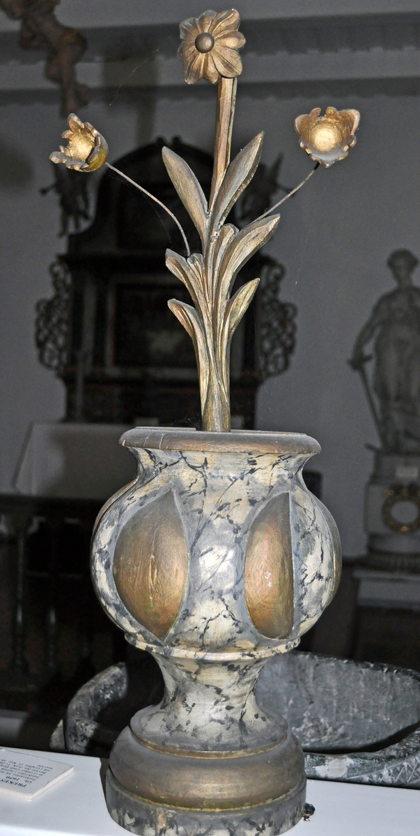 Fra protokollen (Hoel):
Trevase med fritstaaende blomsterprydelser, enten fra prækestolhimlen eller fra korrekkverket i Solum kirke.