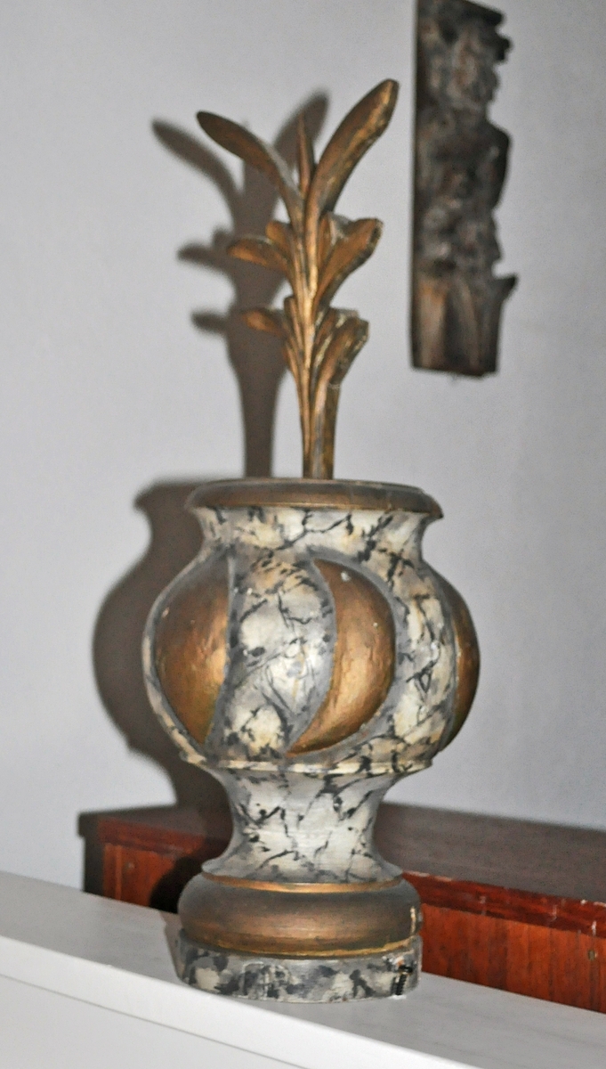 Fra protokollen (Hoel):
Trevase med fritstaaende blomsterprydelser, enten fra prækestolhimlen eller fra korrekkverket i Solum kirke.
