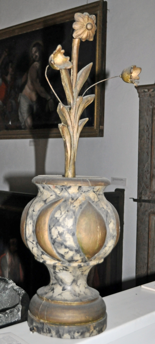 Fra protokollen (Hoel):
Trevase med fritstaaende blomsterprydelser, enten fra prækestolhimlen eller fra korrekkverket i Solum kirke.