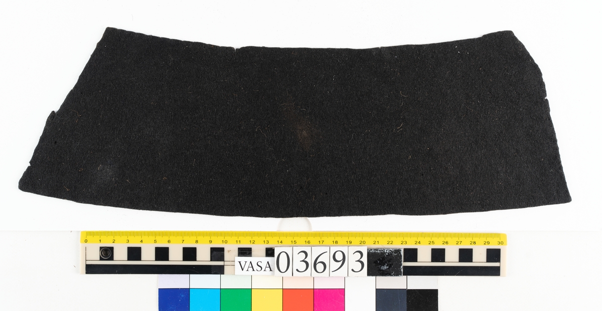 Textil.
2 tillskurna bitar av mörkbrun tät, hård filt. Små runda hål syns på ett flertal ställen på fragmenten, troligen från olika sömmar.

Textildokumentation 2018:

Ingår i kontextgrupp: ÖB31
Fyndnumret 03693 innehåller 2 fragment (ÖB31.5:1-2). Fyndnumret innehåller även ett tråd.
Fragmenten är av filtad ull i mycket fin kvalitet och med en tät filtning. Fragmenten är tillskurna. Det finns tydliga märken efter stygn och stygnhål utefter kanterna. Ca 10 st runda hål, möjligen stansade.
På ena sidan av båda delarna finns snedställda avtryck som liknar avtryck från snedställda pikéringsstygn. Delarna är tillskurna och har jack utefter kanterna som skulle kunna vara passmärken. Spår av kastsöm på delar av kanterna.
Materialet är stelt som om det skulle kunna vara behandlat med något. Ingen tydlig lukt.
Delarnas ena sida har en slätare struktur. 
ÖB31.5:2. På tvären finns spår av ett veck. Vid vecket ett blekt område. Utefter kanter bristningar. 
Det finns små tryckmärken alt. märken av skadeddjur.

Tråden är tunn och vågig, möjlig del av tjockare tråd. 

TEKNIK Typ.nr: ÖB31.5:1-2
Fibermaterial: ull
Garngrovlek (mm): 0,7-0,9
Färg: mycket mörk, möjlig svart

TEKNIK Typ.nr: (ÖB31.5:1-2) tråd:
Antal tråd: 1
Fibermaterial: ull
Spinnriktning: z
Färg: svart

Dokumenterad av AS nov 2017, maj 2018.
Införd av MS juli 2018.