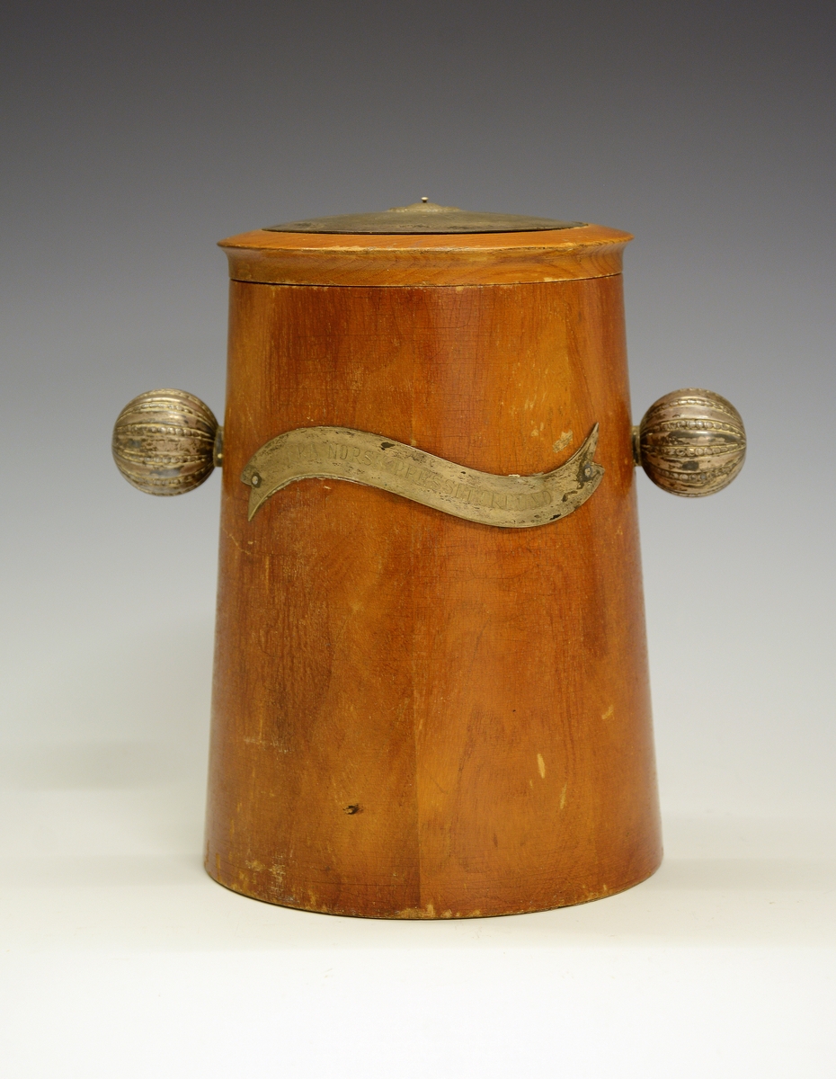 Krukke med lokk. Tre med sølvdetaljer. Sølvbånd med gravering på hver side: FRA NORSK PRESSEFORBUND og TELEMARK PRESSELAG 1908 - 7/11- 1948.