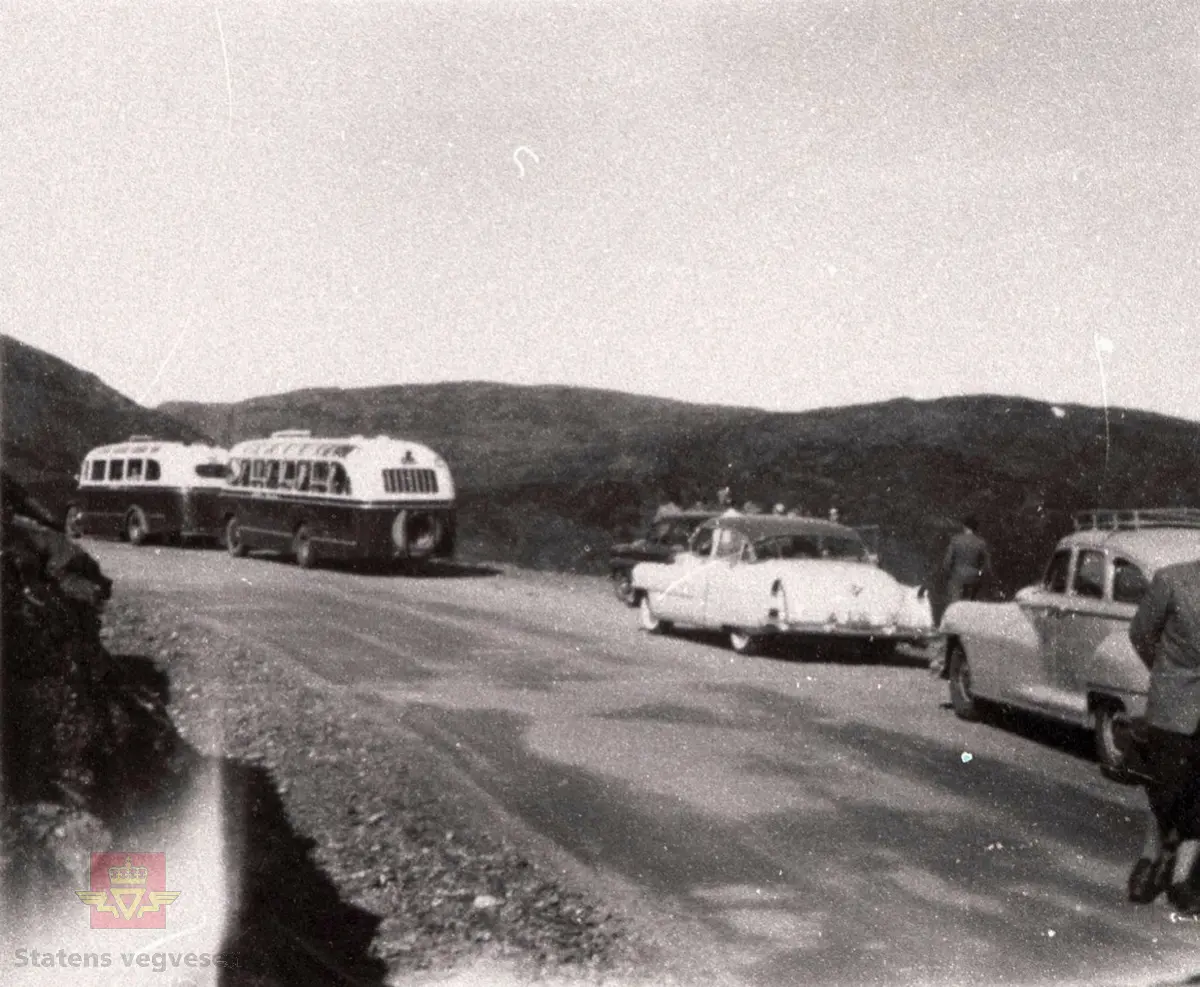 3 bilete frå synfaring og opning av vegen over Vikafjellet mellom Vik og Voss 13. september 1957.  Planen var at Kronprins Olav skulle opna vegen den 28. september 1957, men sidan Kong Haakon døyde 21. september blei opninga utsett eit år. (Informant: Magne Vikøren).

Den offisielle opninga stod samferdsleminister Kolbjørn Varmann frå Eid i Sogn og Fjordane for.

Her er Stortingets Samferdslekomitè truleg ved Storhuag. Bussane er av merke REO med kjenneteikn S-32 og Volvo med kjennteikn S-3023. 

Personbilene er Cadillac fra 50-tallet og Dodge, DeSoto eller Chrysler 1946-1948. (Informant: Ivar E. Stav)

Sjå og motiva NVM 14-F-02611a, NVM 14-F-01719 og NVM 14-F-01723.