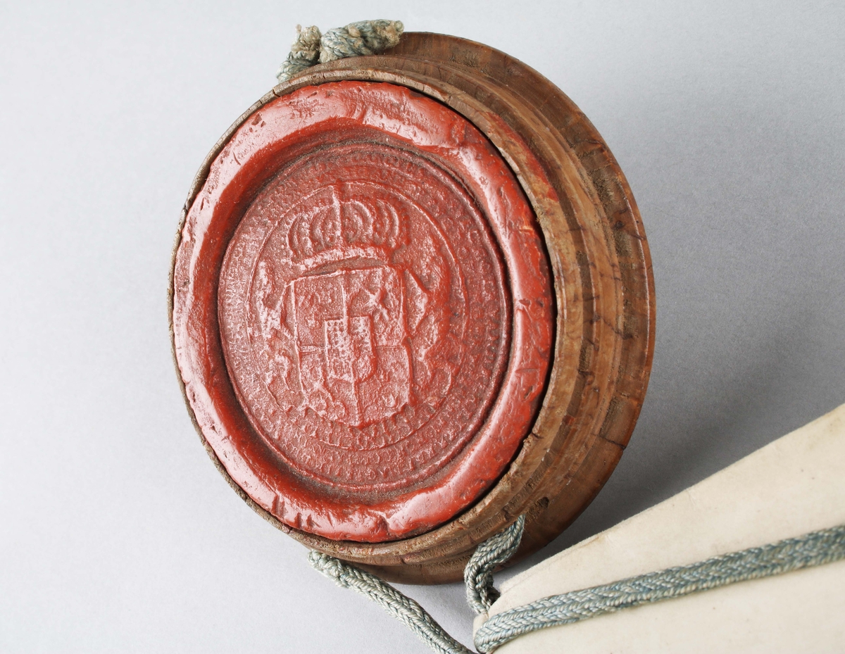 Bytes brev, med tillhörande rött sigill. Handskriven svart text mot vitt papper. Kungligt rött sigill, med Svea rikes vapen, infällt i profilerad träplatta. Brevet skrivet av Kronan1673. Till Arfwid Ifwarson. Signerat: Carolus (Kung Karl XI)

Text börjar med: 
Bytes Bref medh Cronan på Tranwijk, Öfwer by och Humblemohra; Wärmbdöön emoth Godtz i Wästergötlandh. No 13.............

Avslutas med: 
Kong: Slott Stockholm d. Treddie Decemb Åhr efter Christi bördh, Ett Tusendh Sexhundrade och på dhet Siuttijonde och Tridie. Carolus.

Anm: Se hela texten översatt i bildrutan