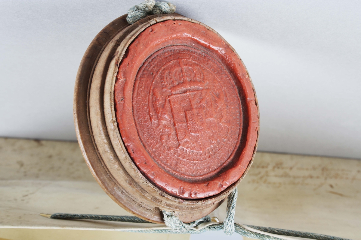 Bytes brev, med tillhörande rött sigill. Handskriven svart text mot vitt papper. Kungligt rött sigill, med Svea rikes vapen, infällt i profilerad träplatta. Brevet skrivet av Kronan1673. Till Arfwid Ifwarson. Signerat: Carolus (Kung Karl XI)

Text börjar med: 
Bytes Bref medh Cronan på Tranwijk, Öfwer by och Humblemohra; Wärmbdöön emoth Godtz i Wästergötlandh. No 13.............

Avslutas med: 
Kong: Slott Stockholm d. Treddie Decemb Åhr efter Christi bördh, Ett Tusendh Sexhundrade och på dhet Siuttijonde och Tridie. Carolus.

Anm: Se hela texten översatt i bildrutan