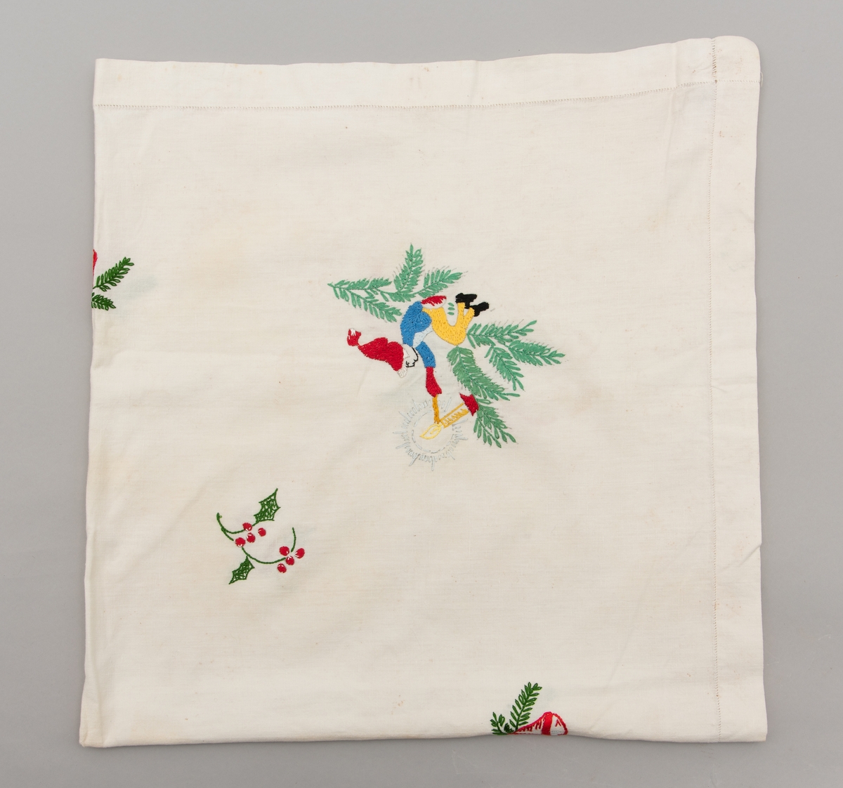 Hvit duk med julemotiver brodert på. Det er brodert julekurver med fargene i det svenske flagget.