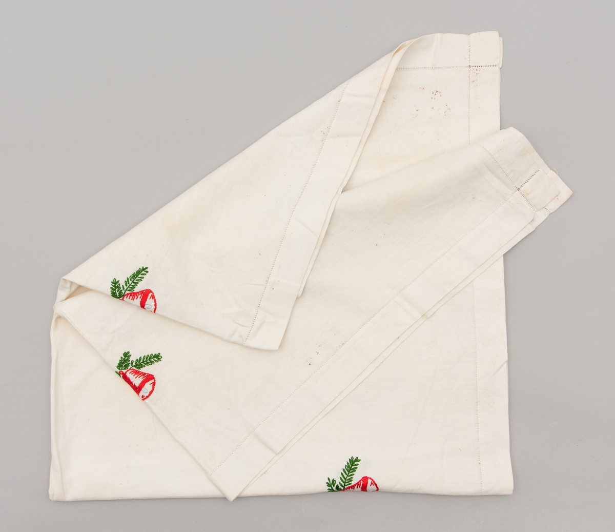 Hvit duk med julemotiver brodert på. Det er brodert julekurver med fargene i det svenske flagget.