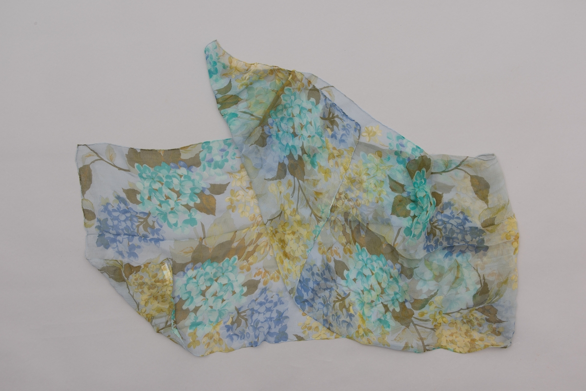 En grå-beige draktkjole og to tynne fargede sjal. Drakta er tredelt med bluse, skjørt og jakke. Drakt og sjal ble brukt sammen.