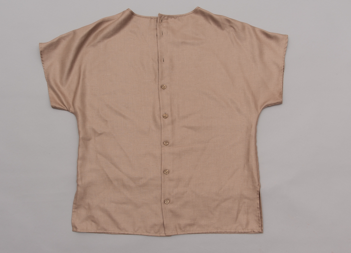 En grå-beige draktkjole og to tynne fargede sjal. Drakta er tredelt med bluse, skjørt og jakke. Drakt og sjal ble brukt sammen.