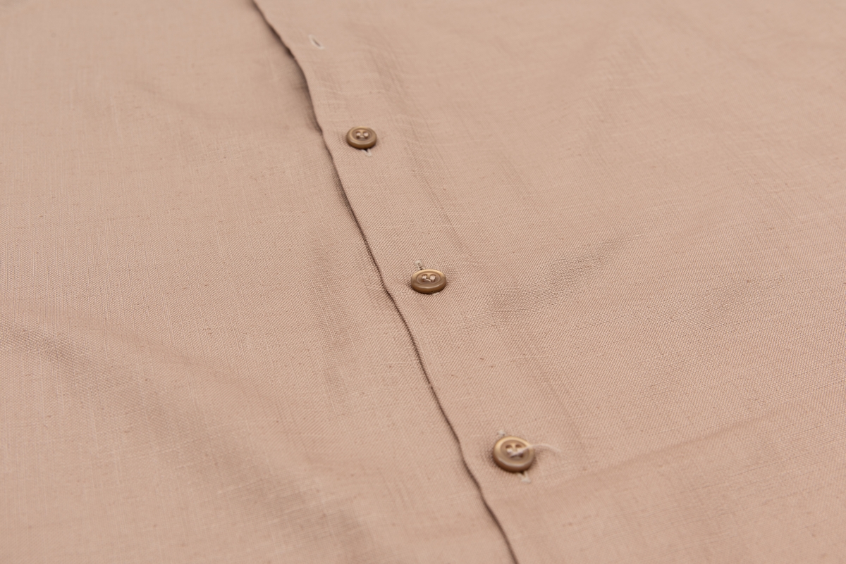 En grå-beige draktkjole og to tynne fargede sjal. Drakta er tredelt med bluse, skjørt og jakke. Drakt og sjal ble brukt sammen.