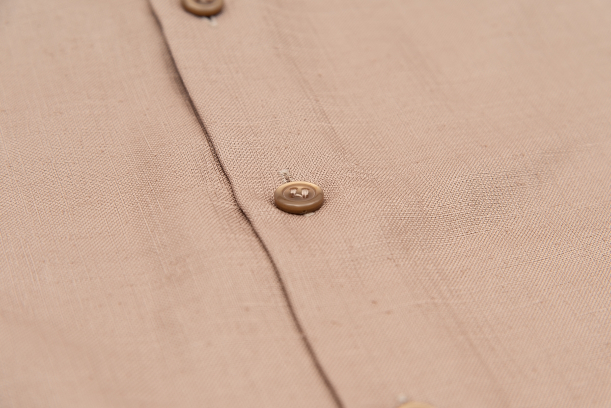 En grå-beige draktkjole og to tynne fargede sjal. Drakta er tredelt med bluse, skjørt og jakke. Drakt og sjal ble brukt sammen.