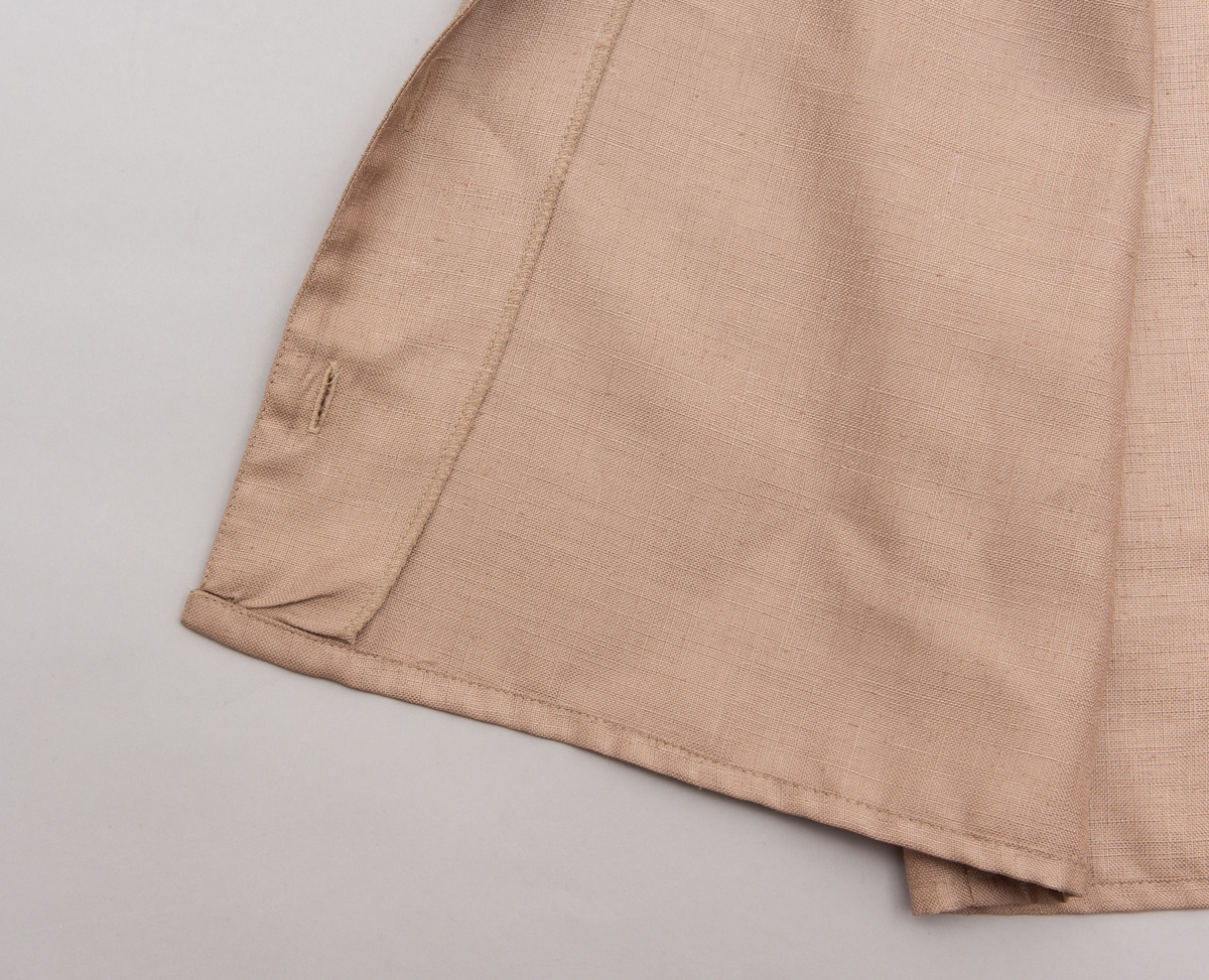 En grå-beige draktkjole og to tynne fargede sjal. Drakta er tredelt med bluse, skjørt og jakke. Drakt og sjal ble brukt sammen.