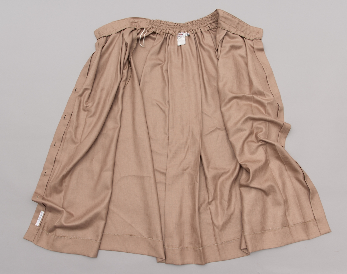 En grå-beige draktkjole og to tynne fargede sjal. Drakta er tredelt med bluse, skjørt og jakke. Drakt og sjal ble brukt sammen.