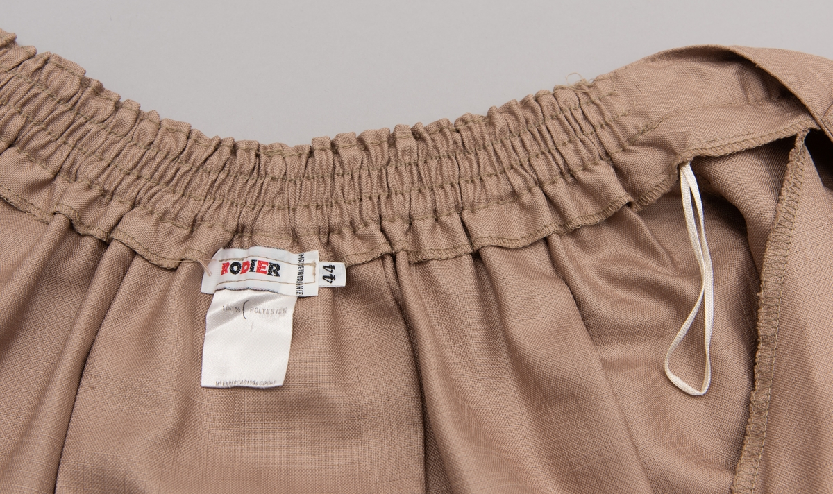 En grå-beige draktkjole og to tynne fargede sjal. Drakta er tredelt med bluse, skjørt og jakke. Drakt og sjal ble brukt sammen.