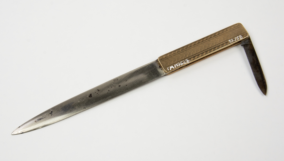 Papperskniv med pennkniv i skaftet. På skaftet inskriptionen Eric H Nelson samt ett emblem med texten "pratt and whitney U.S.A Dependable Engines" på mörkblå botten runt en ljusblå rundel med en flygande fågel i guldinläggning.  Tillverkare Remington U M G USA.