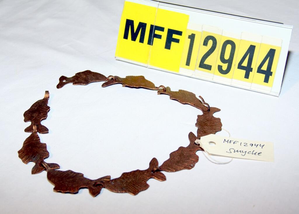 Halsband bestående av 9 länkar av koppar. Fiskliknande. Tillverkare Harry Ekelund.