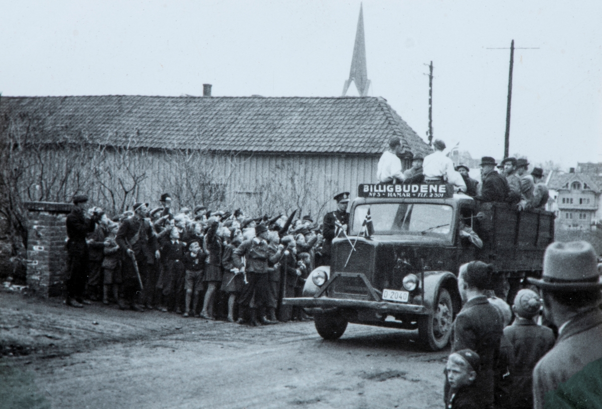 Bilder fra frigjøringsdagene i april og mai 1945. Mye tilskuerer som ser på at en lastebil med arresterte nazister ankommer Hamar fengsel. Billigbudene sto for fangetransporten.