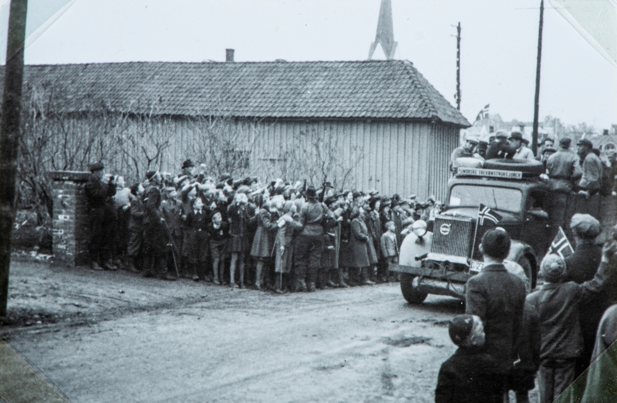 Bilder fra frigjøringsdagene i april og mai 1945. Mye tilskuerer som ser på at en Volvo lastebil med arresterte nazister ankommer Hamar fengsel.