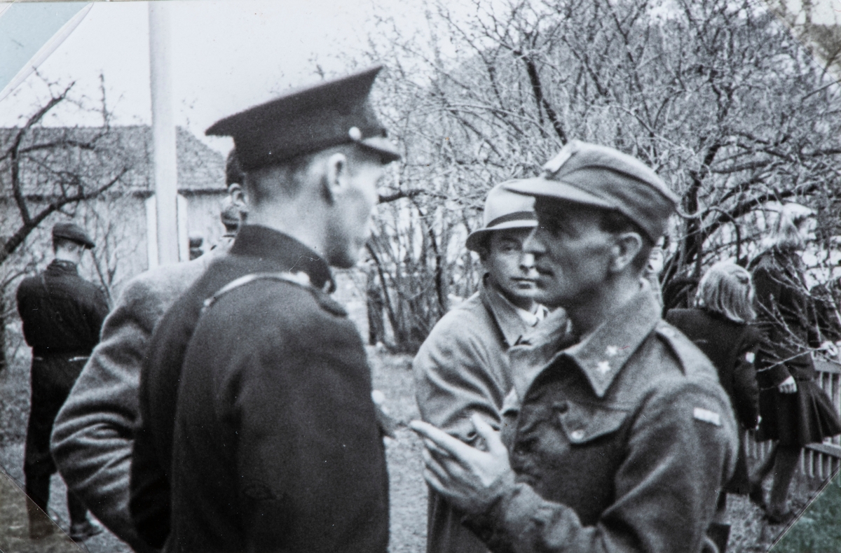 Bilder fra frigjøringsdagene i april og mai 1945. En løytnant fra de Norske styrkene i samtale med politiet utenfor Hamar Fengsel.