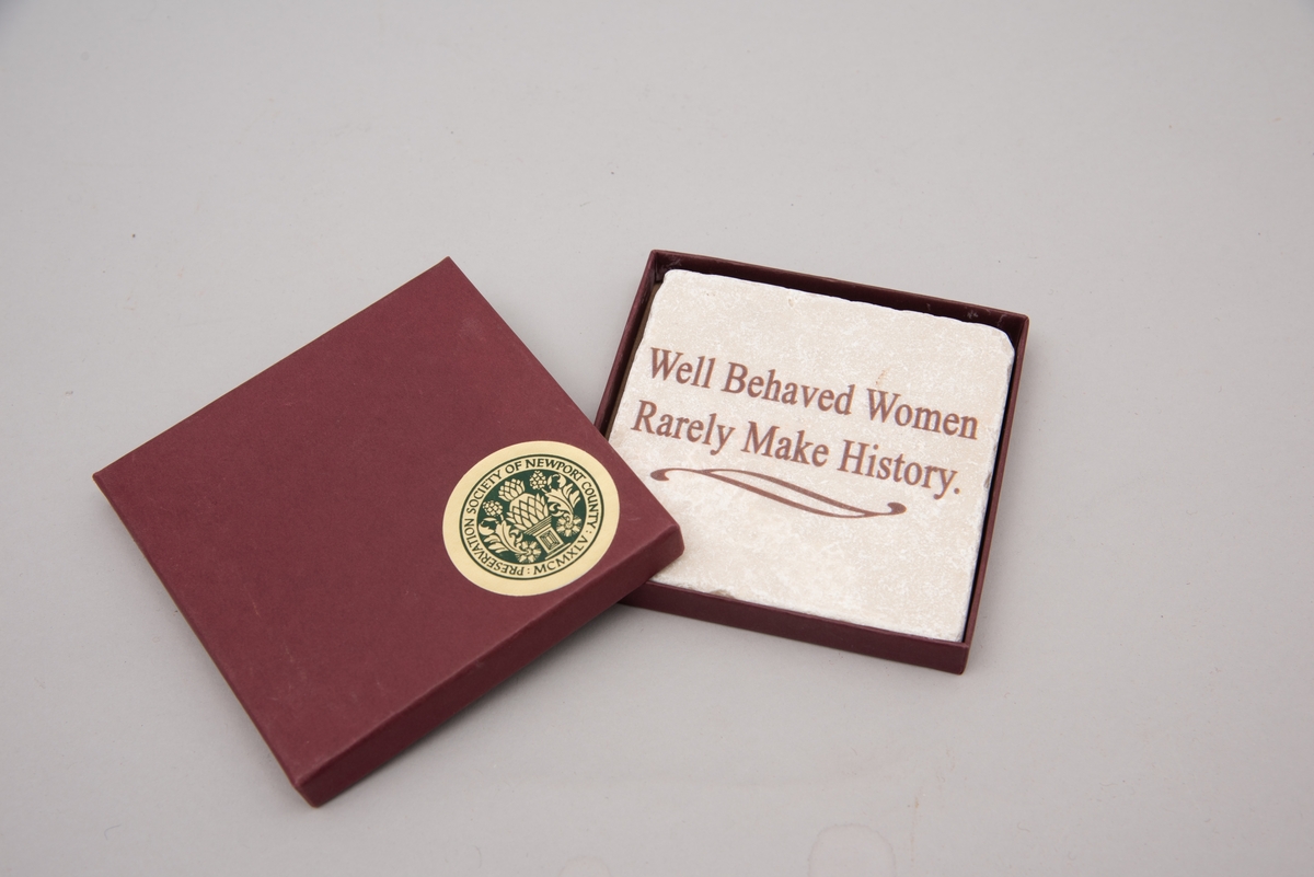 Marmorflis og souvenir fra Newsport Mansions med påført slagord "Well Behaved Women Rarely Make History". Tilhørende eske og informasjonsfolder. Mottoet påført marmorflisa er i ettertida blitt brukt til å beskrive Alva Vanderbilt Belmont (1853-1933) og andre kvinner som kjempet for kvinners stemmerett på begynnelsen av 1900-tallet i USA under slagordet "Votes for Women". Selve "Votes for Women"-mottoet ble brukt i 1909 på et berømt "open house" stemmerettsmøte holdt på Marble House, Newport, Rhode Island".