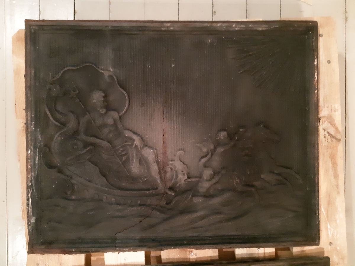 Etasjeovn i støpejern, tre etasjer. Motiv Neptun på fyringskasse. Etasjene med rocailler. Trekrakk, oker farge, kannelerte avsmalnede ben med diamant øverst. 25 deler