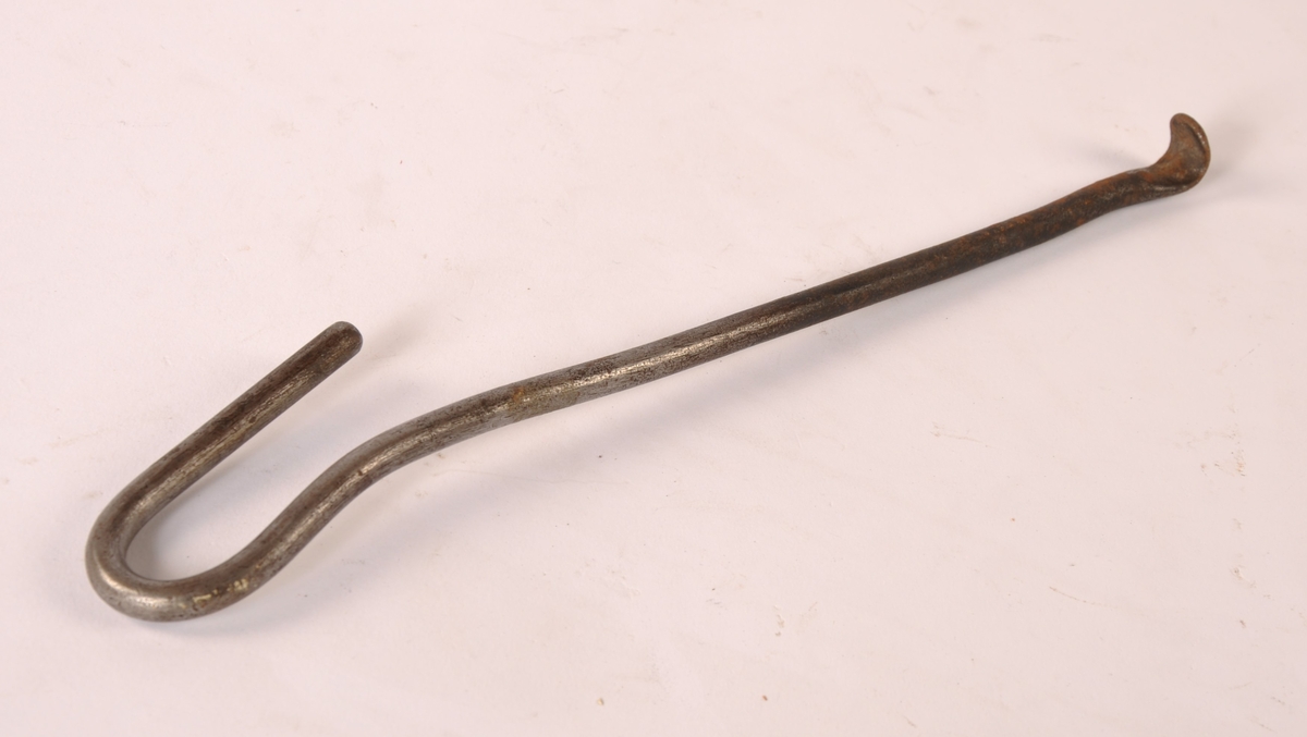 Komfyr i støpejern med venstrehengslet ileggsdør til venstre og to luker til høyre, fem plater med ringer på toppen. Står på fire svungne ben. Dør med norske løve og planteornamentikk. Tilhørende løs messingstang til front, askekrok av jern,  ringkrok av jern og blåmalt rektangulær vedkasse av tre.