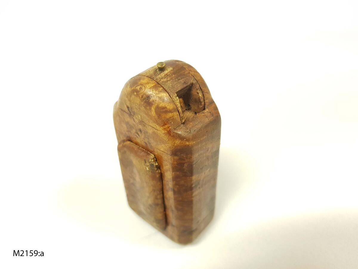 Snusdosa, av masur. Rektangulär med ena kortsidan kraftigt utsvängd. Denna sida med vridbart hjul. Litet lock, märkt 1802. Ramsele socken, Ångermanland. (Ur lappkatalogen).