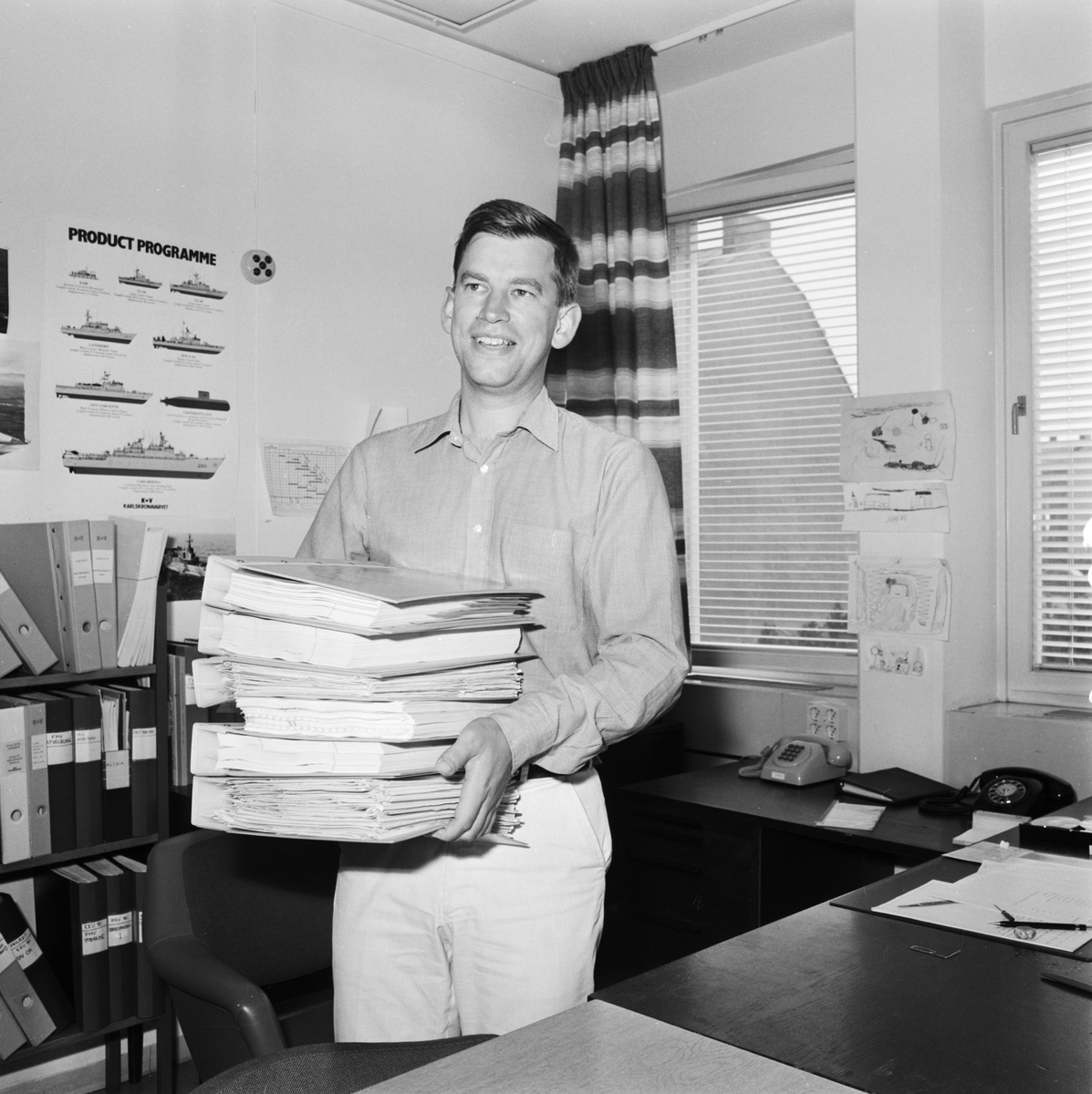 Varvet runt- en bildutställning
Civilingenjör John Nilsson, Kontruktionskontoret, med offerthandlingarna för kustkorvett typ Göteborg 1985.\\Sedan 1970-talet har Konstruktionskontorets tekniska kompetens förstärkts, bl a genom en markant ökning av högskoleutbildad personal.