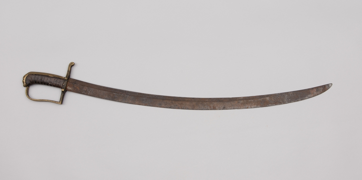 Sabelen er litt krum. Avviket frå rett line gjennom skjefte- aksen er 14.5 cm på 78 cm (mælt frå toppen av skjeftet).Skjeftet har parerstong av messing,ein volutt på den rette toppenden. Under går parerstonga vinkelrett over i ein litt boga vernebøyle opp mot skjeftetoppen av messing, forma som anletsmaske. Grepet er av lær. Klingen av stål har smal blodrand og har utvendig egg.