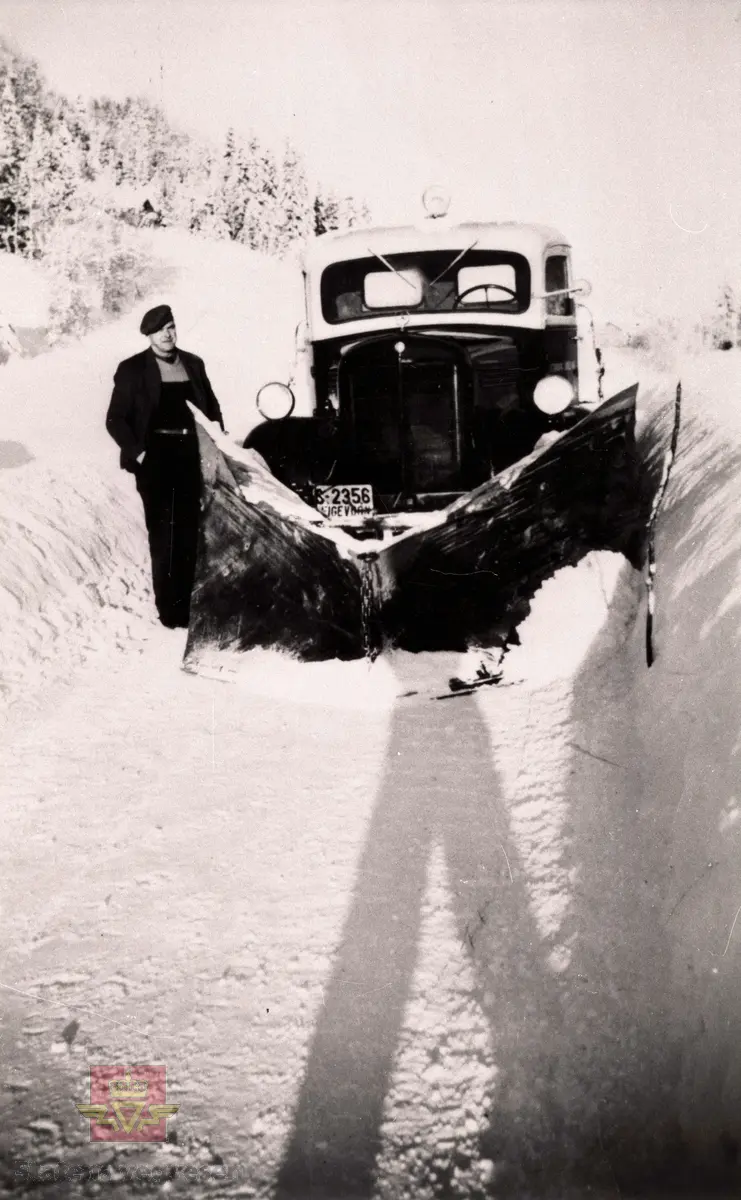 Snøbrøyting i Angedalen i Førde kommune. 

Ved sida av brøytebilen står vegvokter Gustav Frøysland. 