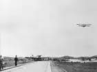 Flyghamnen i Torslanda vid Internationella luftfartsutställningen, ILUG i Göteborg, 1923. Flygplan Junkers F 13 på marken. Flygbåt i luften. Människor i rörelse.