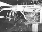 Närbild av flygplansdelar på ett havererat flygplan Thulin A står i en hangar, 1910-tal.