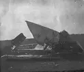 Havererat flygplan Thulin A ligger på ett fält, omkring 1915-1920.