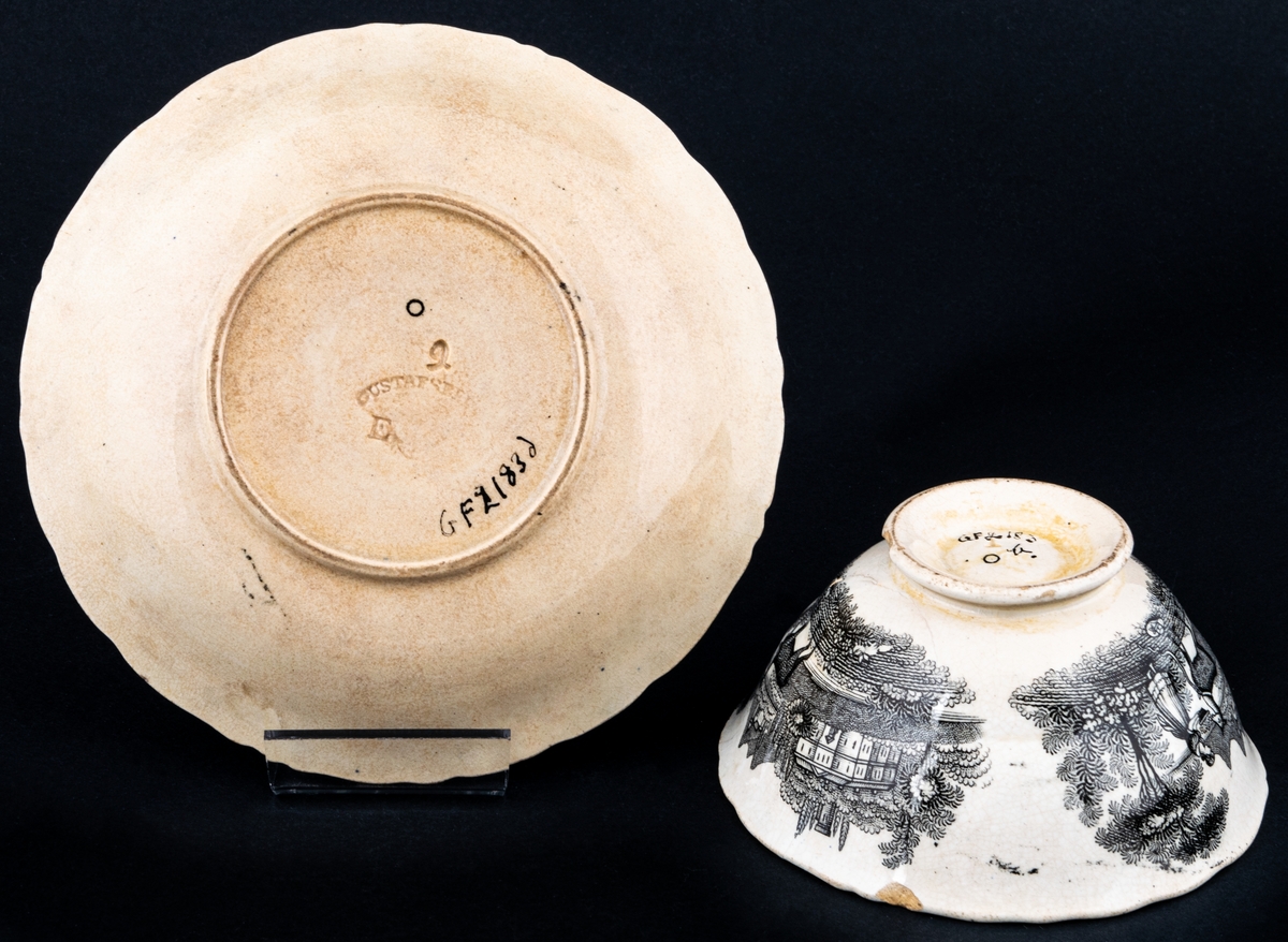 Kaffekopp och fat, med svartvit dekor med landskapsmotiv och blommor. Tillverkad vid Gustavsbergs porslinsfabrik.